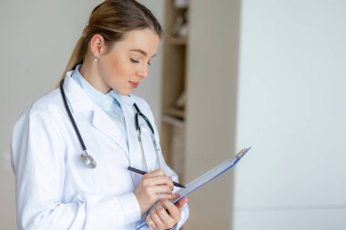 Bir sağlık uzmanı bilgi kaydetmeye odaklanır. Sağlık, profesyonellik ve doktor-hasta ilişkileri kavramları.