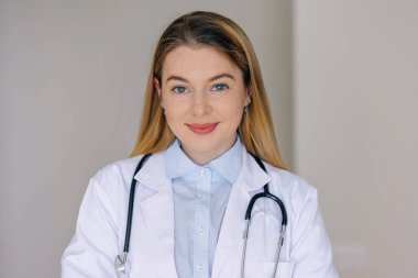 Profesyonel bir ortamda steteskop takmış gülümseyen genç bir bayan doktor. beceri, profesyonellik ve dostluk