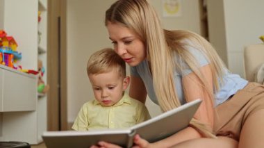 Anne ve küçük oğlu rahat bir odada kitap okuyorlar.. 