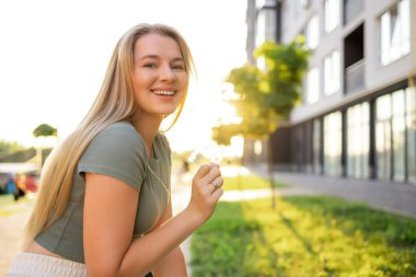Gülümseyen genç kadın diş hekimi, diş sağlığı ve mutluluk kavramını gösteriyor..