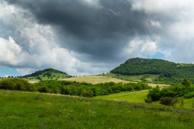 Avrupa 'nın ücra bir bölgesinde, yazın dalgalı çim tarlaları olan güzel dağ manzarası.