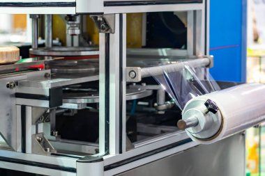Endüstriyel çalışmalarda eşyalar veya ürünler için otomatik paketleme ya da paketleme makinesinin plastik germe filmini kapat