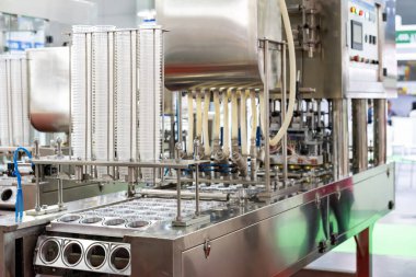 Gıda içeceği veya krema sosu paketlemek için otomatik doldurma ve mühürleme makinesinin beslenme ünitesine bağlı şeffaf plastik bardak seti. endüstriyel