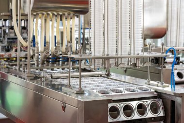 Gıda içeceği veya krema sosu paketleme için otomatik doldurma ve mühürleme makinesinin beslenme ünitesine bağlı sıra şeffaf plastik bardağı kapatın. endüstriyel