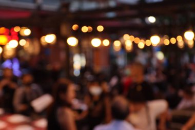 Restorandaki bulanık görüntü, restorandaki birçok insan yemek yiyor ve eğleniyor. 