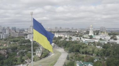 Ukrayna bayrağı şehrin arka planında rüzgarda dalgalanıyor. Hava fotoğrafçılığı. Kyiv. Ukrayna.