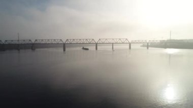 Petrovsky railway bridge over the Dnieper River, Ukraine, Kyiv city. Drone video. Autumn. Fog. 