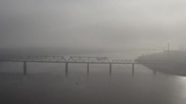 Petrovsky railway bridge over the Dnieper River, Ukraine, Kyiv city. Drone video. Autumn. Fog. 