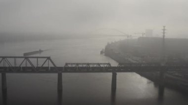 Petrovsky railway bridge over the Dnieper River, Ukraine, Kyiv city. Drone video. Autumn. Fog. 