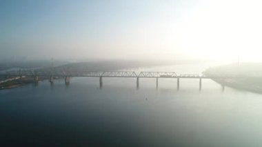 Petrovsky railway bridge over the Dnieper River, Ukraine, Kyiv city. Drone video. Autumn. Fog. 
