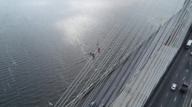 Güney köprüsünün hava aracı, Kiev şehri. Ukrayna. Dinyeper nehri, köprü nehri geçer. Nehirdeki şehir manzaralı köprü. İki adam köprünün tepesine tırmanıyor.