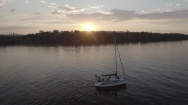 The yacht sails along the Dnieper river at sunset. View of the general plan of the city. Silhouette of the city. Ukraine. Aerial. 