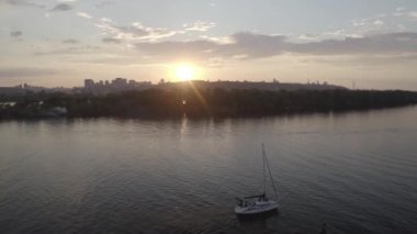 The yacht sails along the Dnieper river at sunset. View of the general plan of the city. Silhouette of the city. Ukraine. Aerial. 