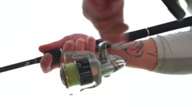 Teknedeki bir balıkçı bir ısırıktan sonra balığı çeker. Balık oltası. Ukrayna.