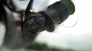 Teknedeki bir balıkçı bir ısırıktan sonra balığı çeker. Balık oltası. Ukrayna.