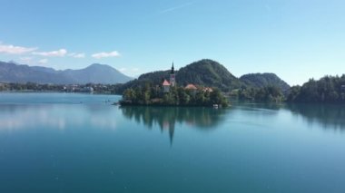 Gölün ortasındaki Mary Varsayımı Kilisesi Bled. Slovenya. Havadan. Yaz. İnsansız hava aracı videosu. Bled Gölü 'nde küçük bir adada uçmak. Mavi su ve orman..