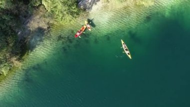 Arkasında Avrupa Alpleri olan Bohinj Gölü. Slovenya. Havadan. Yaz. Turistler kanolarda yüzerler..