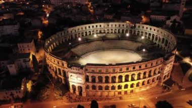 Hırvatistan 'ın Pula kentinde amfitiyatro, gece hava manzarası. Pula 'nın tarihi merkezi. Roma amfitiyatrosunun kalıntıları. 