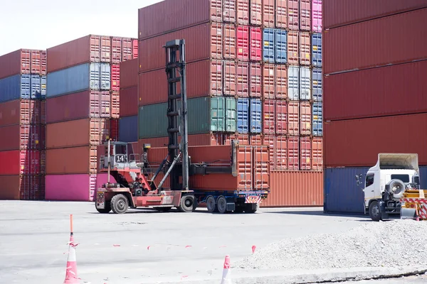 Container forklift and containers piled up at the port.