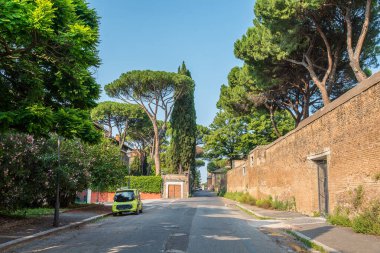 Roma 'nın eski tarihi şehrinde çam ağaçları ve küçük arabalı yeşil yol