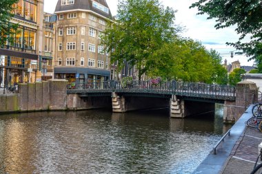 Tekneleri ve köprüleri olan geleneksel Amsterdam kanalı