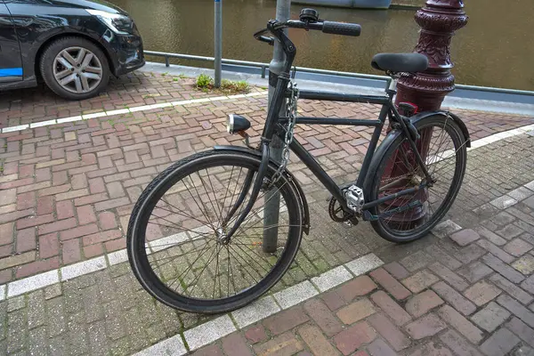 Bicycle locked with a thick chain to the pole
