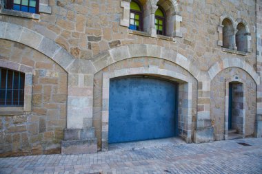 Araba yerine garajı olan eski taş gotik bir bina.