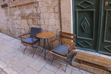 Ortaçağ şehrinin taş sokağında boş sandalyeler ve masa