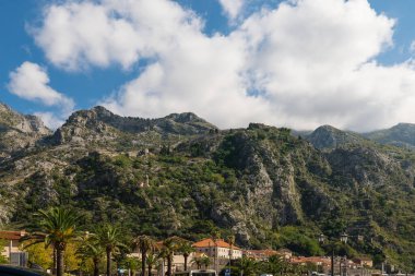 Dağları ve mavi gökyüzü olan Kotor Kalesi surları, Karadağ