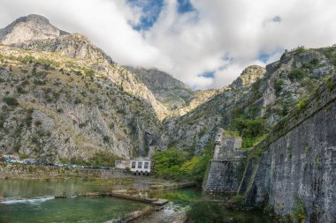 Dağları ve mavi gökyüzü olan Kotor Kalesi surları, Karadağ