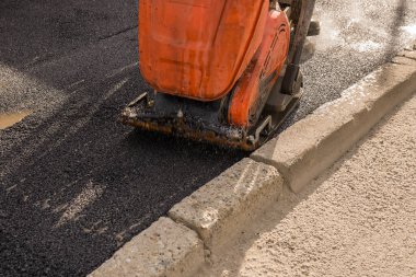 Kaldırım için yeni bir asfalt tabaka seriyorum.