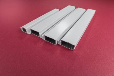 Kırmızı arkaplanda el kesimi alüminyum profilleri