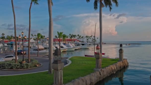 カリブ海の日没を背景にボートや車の駐車場と市内中心部の海岸の美しい景色 アルバだ オラニエスタッド 2022 — ストック動画