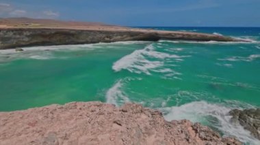 Büyük turkuaz dalgaların muhteşem manzarası Atlantik Okyanusu kayalık Aruba adası kıyılarında.