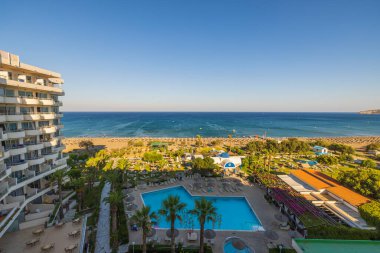 Akdeniz 'de açık havuzu ve plajı olan güzel bir otel manzarası. Rodos. Yunanistan. 07.15.2022.