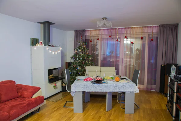Beautiful view of room with Christmas decoration and served table. Sweden.