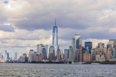 Beyaz bulutlu mavi gökyüzü altında Hudson Nehri 'nden Manhattan' ın güzel panoramik manzarası. New York, ABD.