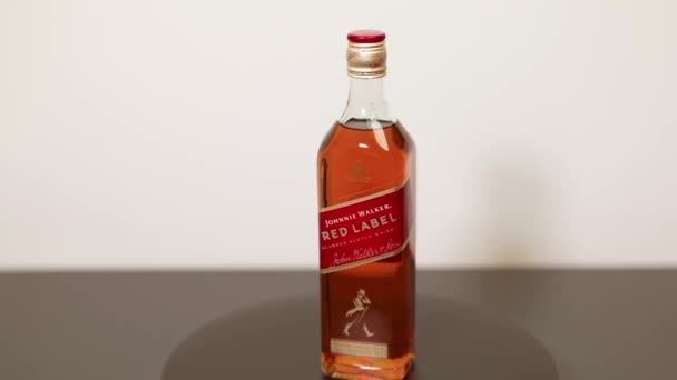 Nahaufnahme Von Drehen Flasche Whisky Johnnie Walker Red Label Auf — Stockvideo