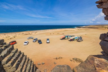 Park halindeki arabaların ve Atlantik Okyanusu manzarasının Bushiribana harabelerinden görüntüsü. Aruba. Oranjestad. 12.08.2022.