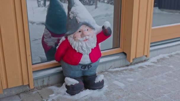 寒い冬の日に家に正面のドアの前に立って 雪で覆われたノームのかわいい置物のビューを閉じます スウェーデン — ストック動画