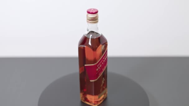 Крупный План Вращающейся Бутылки Виски Красной Этикеткой Джонни Уокера Уппсала — стоковое видео