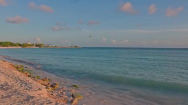 Ufukta mavi gökyüzü ile birleşen sakin turkuaz su ile Karayip Denizi 'nin güzel gün doğumu manzarası. Aruba.