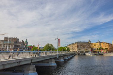 Beautiful cityscape view of central Stockholm with Pedestrians, cyclists and cars passing through bridge. Sweden, Europe. Stockholm. 05.18.2022.