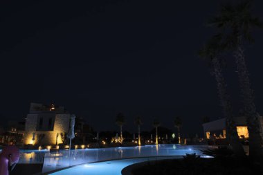 Beautiful night view of hotel area against backdrop of an outdoor pool. Greece. Nea Potidaea. 09.05.2022.