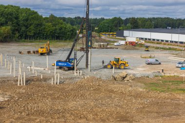 Industrial view of construction site with machinery and pile driving machine for driving piles into ground. Sweden. Enkoping. 05.08.2022