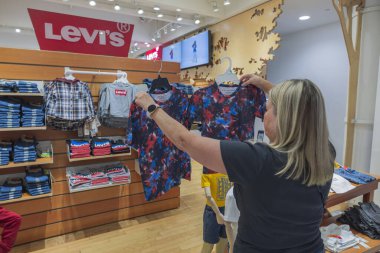 Woman choose T-shirt in children's department for shop Macy's supermarket. New York. USA. 09.21.2022.