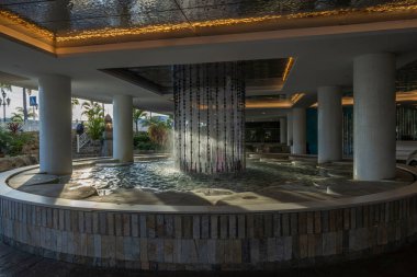 Close-up view of beautiful made fontaine composition under roof of parking of hotel. Oranjestad, Aruba. 