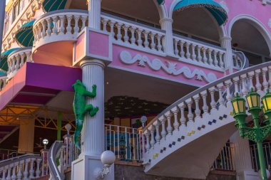 Cute green iguana figure on facade of hotel building. Oranjestad. Aruba. 02.16.2023.