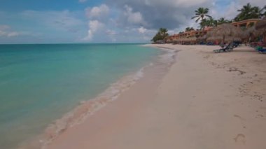 Atlantik Okyanusu 'nun turkuaz suyuyla kumlu güzel bir otel manzarası. Aruba.