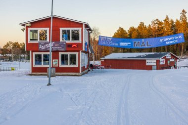 View at building of ski sport club on forest trees and pale sky background. Sweden. Storvreta. 02.26.2023.